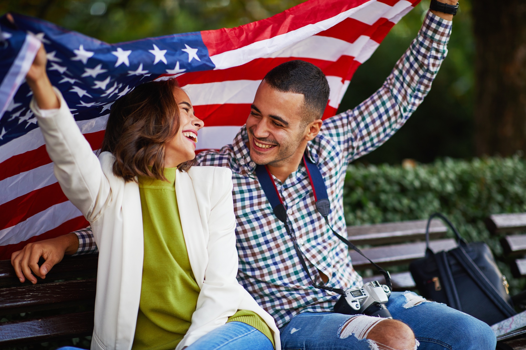 Happy young couple of tourists with a USA flag